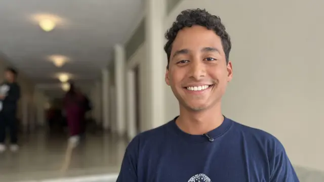 Студент университета Самуэль Ариас улыбается в камеру.