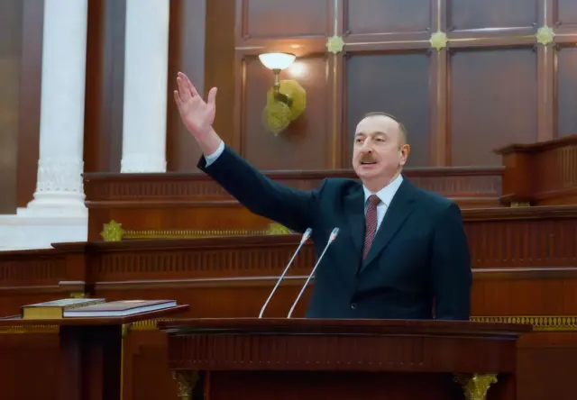 Алиев выступает на трибуне азербайджанского парламента.