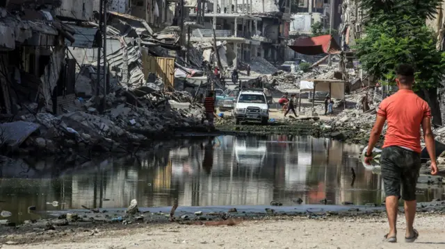 Un hombre pasa por una calle destrozada de Gaza.