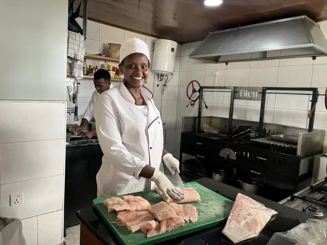 Nyamwiza Cécile arimo gutegura inyama mu gikoni