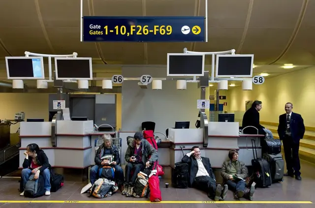 Passengers wait in front of check-in counters after the cancellation of flights at Arlanda Airport outside Stockholm, on April 15, 2010. Sweden's airspace will shut by 2000 GMT today due to the ash cloud created by a volcano eruption in Iceland, the country's civil aviation authority said. AFP PHOTO PONTUS LUNDAHL/SCANPIX SWEDEN -- SWEDEN OUT-- (Photo credit should read PONTUS LUNDAHL/AFP via Getty Images)