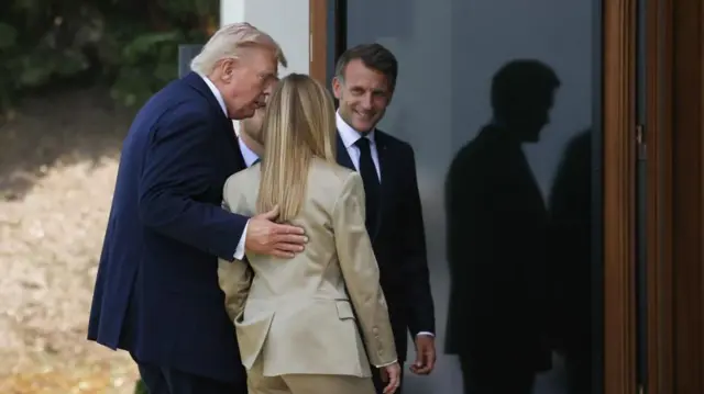 庭園からサミット会場のホテルに入る首脳たち。トランプ氏がメローニの背に手をまわし、マクロン仏大統領が笑顔で迎え入れている