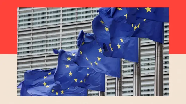 Európai uniós zászlók lobognak az Európai Bizottság székháza előtt.
