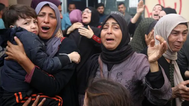 İsrail hava saldırısında öldürülen cesetlerin yanında ağlayan Filistinli kadınlar ellerini havaya açmışlar