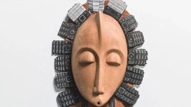 Oloya amejumuisha simu za mkononi za zamani kwenye kinyago hiki cha jadi cha bibi harusi