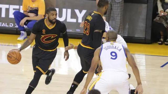 Kyrie Irving (2) mueve la pelota mientras LeBron James (23) de los Cavaliers bloquea a Stephen Curry (30) de los Warriors en la primera mitad en el séptimo partido de las Finales de la NBA.