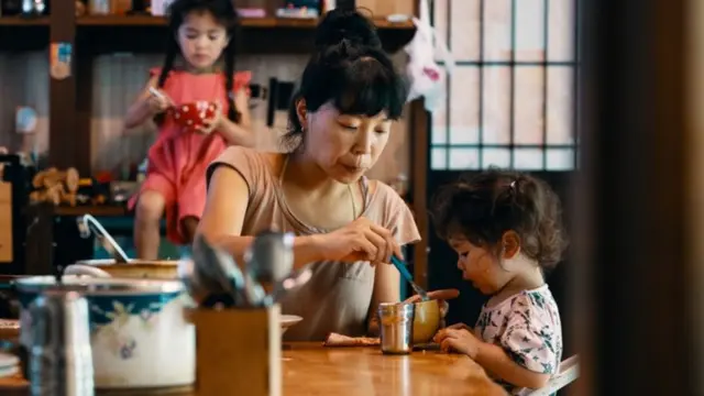 Mulher dando comida para criança