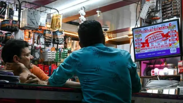 टीवी पर पोल देखते लोग