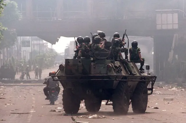 Pasukan khusus militer Indonesia berpatroli di sekitar lokasi yang rusak dari kerusuhan kekerasan 14 Mei antara massa Indonesia yang marah dan pasukan keamanan di pusat kota Jakarta 15 Mei.