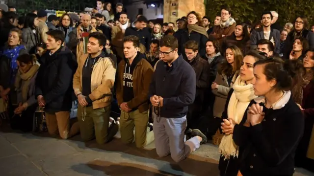 Personas rezan en los alrededores de Notre Dame