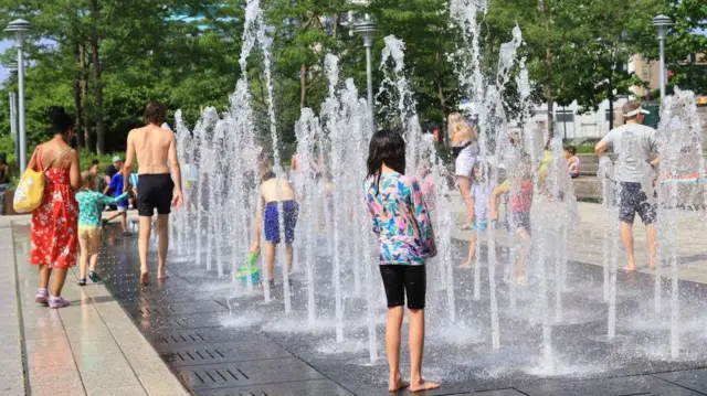 ਨਿਊ ਯਾਰਕ ਅਮਰੀਕਾ ਵਿੱਚ ਸੋਮਵਾਰ ਨੂੰ ਬੱਚੇ ਜਨਤਕ ਫੁਹਾਰਿਆਂ ਵਿੱਚ ਗਰਮੀ ਤੋਂ ਲੁਕਦੇ ਹੋਏ
