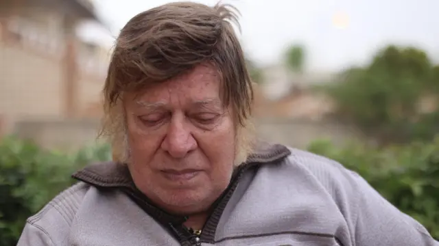 The late Mimi El-Sherbiny wearing a gray shirt