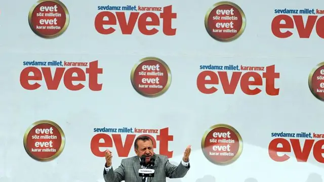 Recep Tayyip Erdoğan, "evet" yazan bir pankartın önünde konuşuyor.
