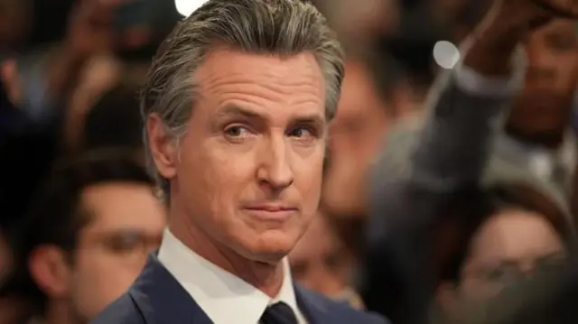 Gavin Newsom olhando para o lado, com olhar sério