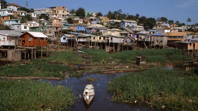 Criança conduzindo canoaaviator f12betigarapé pertoaviator f12betcasasaviator f12betpalafitas