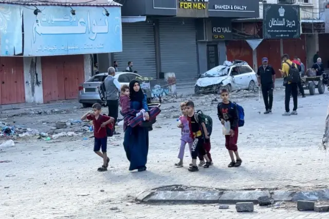 سيدة وخمسة أطفال يحملون ما تمكنوا من حمله من أمتعتهم، وقد نزحوا من مخيم جباليا للاجئين