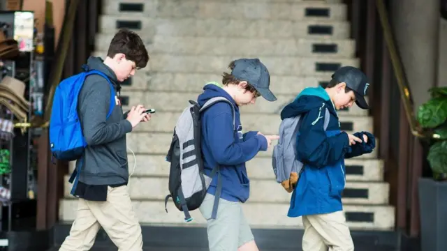 一路看手机的三名男学生