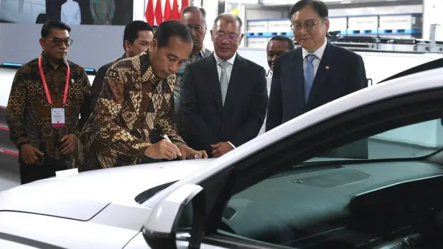Presiden Joko Widodo (kiri) disaksikan Executive Chairman Hyundai Motor Group Euisun Chung (kedua kanan), dan Menteri Perdagangan, Investasi dan Energi Korea Selatan Inkyo Cheong (kanan) menandatangani mobil Hyundai Kona Electric saat peresmian pabrik baterai kendaraan listrik PT Hyundai LG Industry (HLI) Green Power di Karawang, Jawa Barat, Rabu (3/7/2024).