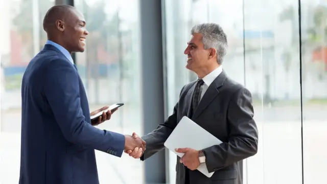 موظفان يتصافحان ويبتسمان