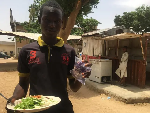 Man dey hold food for hand