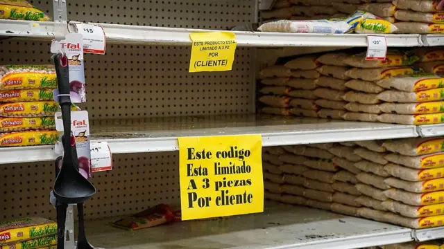 Un estante de supermercado vacío con un cartel que dice "limitado a 3 piezas por cliente"