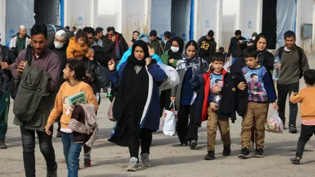 مهاجران افغانی که از ایران اخراج می شوند، وسایل خود را در یک مرکز ثبت نام در شهر مرزی اسلام قلعه ولایت هرات حمل می کنند