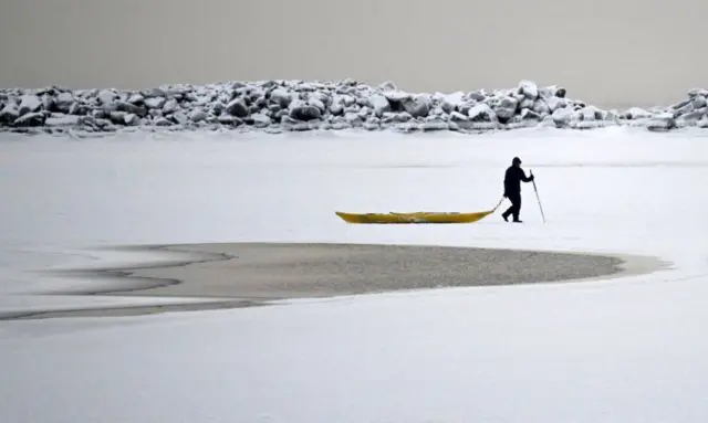 A man walks on the frozen sea in Helsinki, Finland.