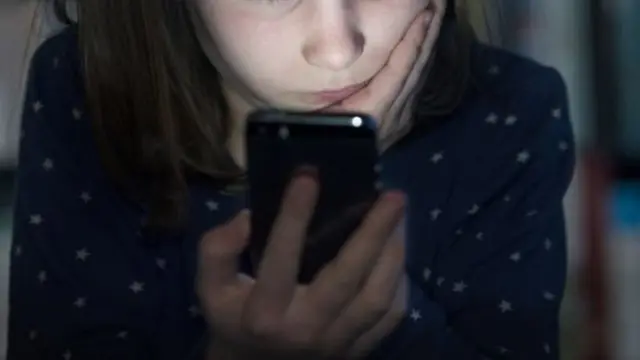 Qız telefonuna baxır