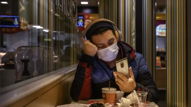 A man wears a protective mask while eating in a McDonald"s restaurant in Beijing, China.