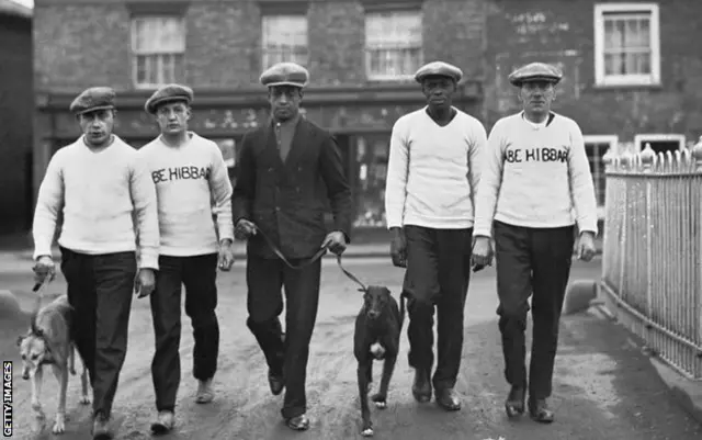 Johnson, centre, pictured with his father and manager Bill (second from right) in Manchester, December 1926