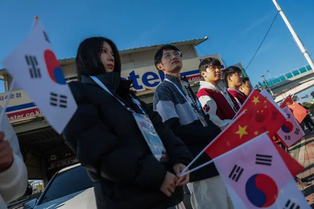 韩国民众手举韩国和中国国旗挥舞。