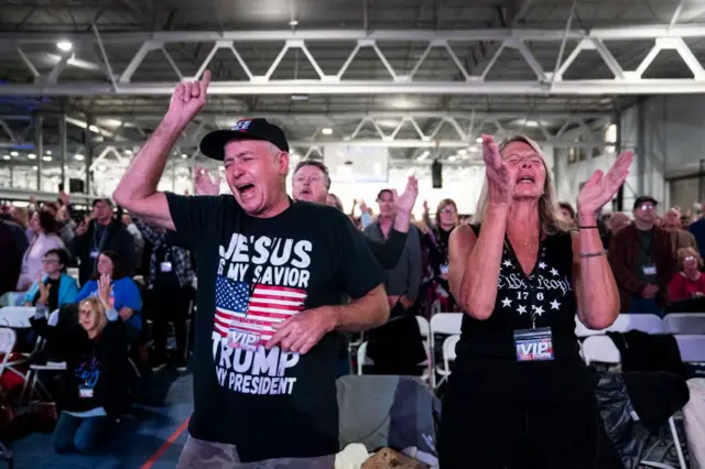 Apoiadores de Trump em um culto religioso durante um evento do ReAwaken America Tour em Manheim, na Pensilvânia, em outubro de 2022

