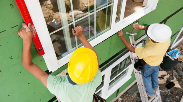 Homens trabalhando na construção de uma casa 
