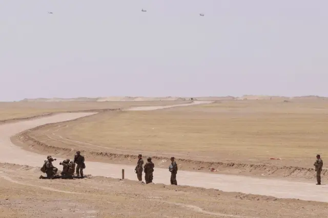 Çöl ortamında sekiz ABD askeri var. Bir tatbikat yapılıyor. Onlardan başka kimse yok karede.