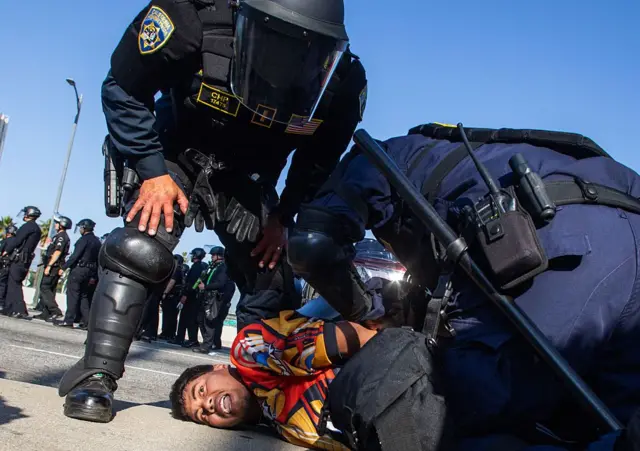 Una persona detenida durante las protestas en Los Ángeles contra las redadas.