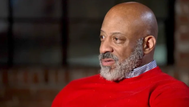 Daniel Evans, yöneticilik yaptığı dönemde kadınların seks için uçakla New York'a getirildiğini anlatıyor. Üzerinde kırmızı bir kazak var.