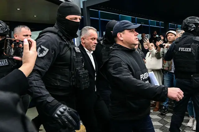 Молдовський олігарх Володимир Плахотнюк (у центрі) у чорному, виходить з міжнародного аеропорту Кишинева під поліцейським ескортом 