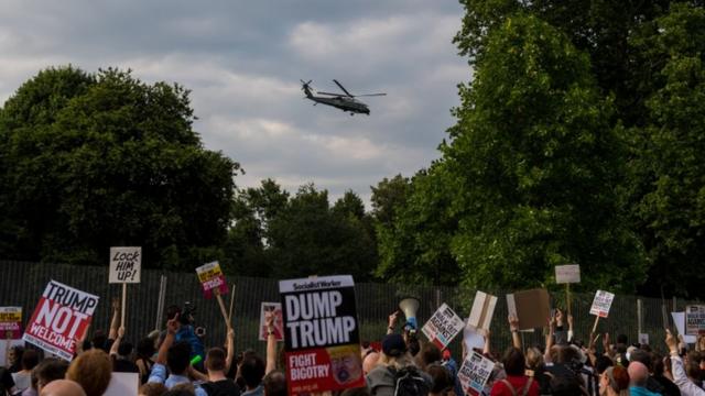 اینجا کاروان هلی‌کوپترهای حامل آقای ترامپ از بالای سر معترضان در آکسفوردشایر رد می‌شود
