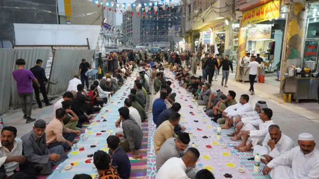 Des musulmans rompent leur jeûne le cinquième jour du mois sacré du Ramadan dans la rue Imam Zeynel Abidin, à la table du sol, à Najaf, en Irak, le 06 avril 2022