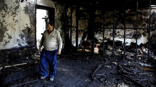 Житель городка Барда в сгоревшем от ракеты доме