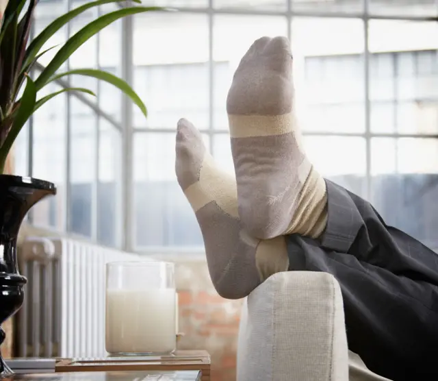 Homem deitado no sofá com os pés para cima