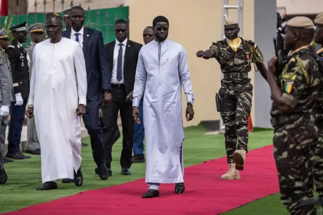 Le président sénégalais Bassirou Diomaye Faye (C), arrive au cimetière militaire de Thiaroye le 1er décembre 2024 pour la cérémonie marquant le 80e anniversaire du massacre des Tirailleurs sénégalais.