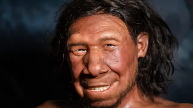 Reconstrucción del rostro de un neandertal de cabello y ojos oscuros que sonríe