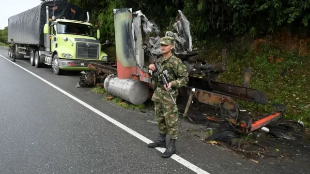 Policía parado junto a otro camión quemado cerca de Yarumal, también en el departamento de Antioquía.