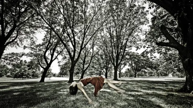 Mujer flotando en bosque