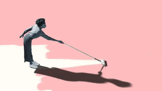 A young woman painting the floor pink