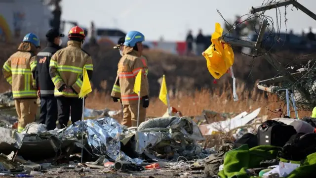 機体近くでねじ曲がったフェンスに黄色いライフジャケットがひっかかった様子