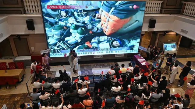 香港一處商場組織觀看神舟二十三號升空直播。