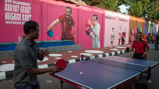 Warga bermain tenis meja saat Peresmian Kampung Asian Games di Pucang Sawit, Solo, Jawa Tengah, Minggu (15/7).