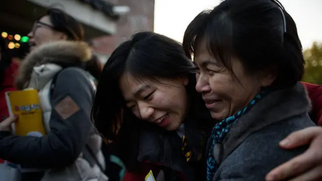 Una estudiante abraza a una mujer que la acompaña cuando llega para rendir el examen anual de capacidad académica universitaria, o examen de ingreso a la universidad, en la escuela secundaria Poongmun en Seúl el 13 de noviembre de 2014.